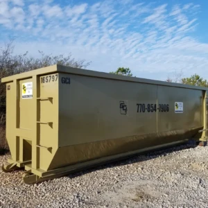 Roll Off Dumpster on a gravel surface with a clear blue sky in the background.
